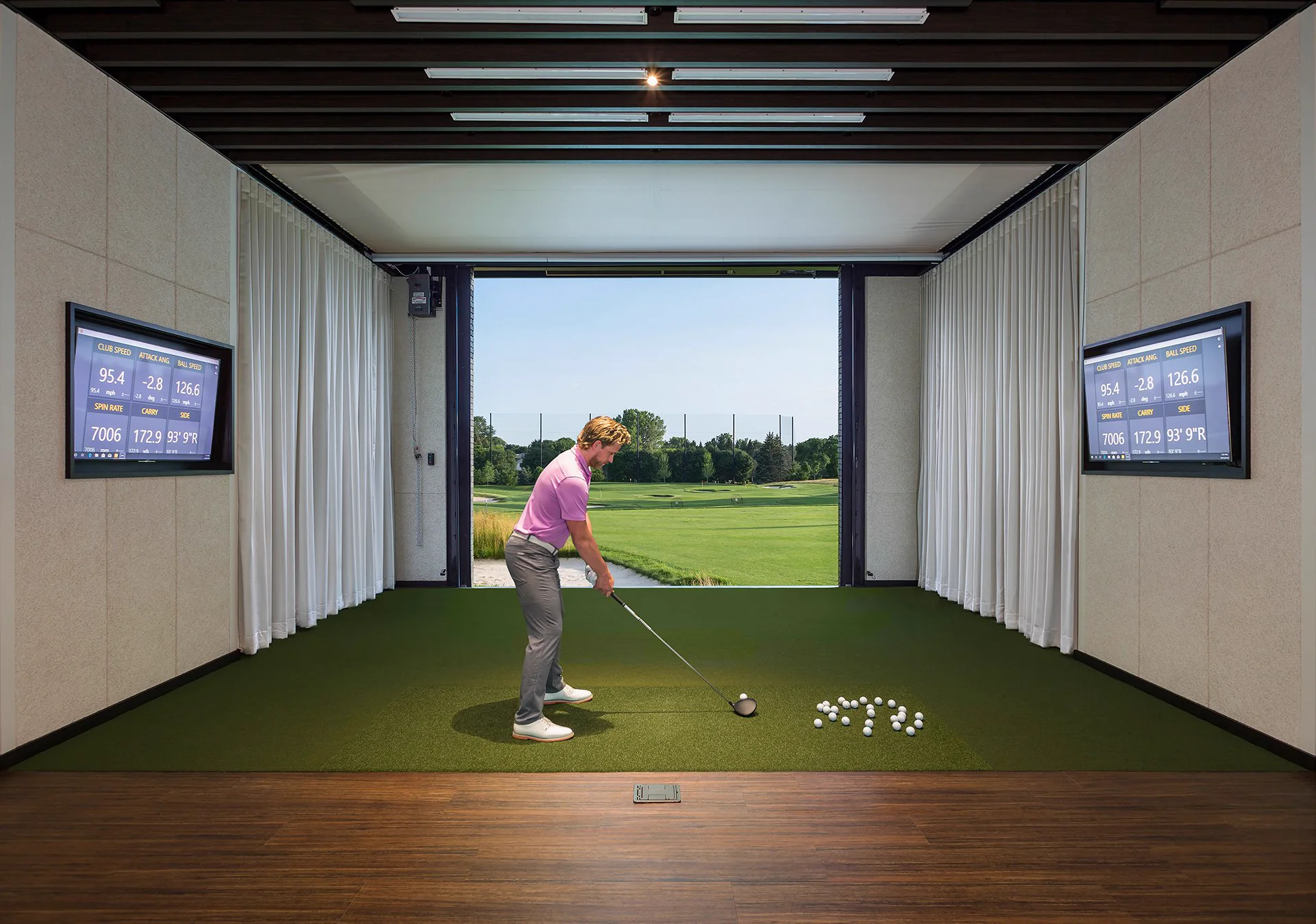 Screenshot Golf screen retracted above a club hitting bay opened to the course